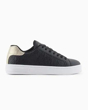 Sneakers nere Armani Exchange in similpelle liscia con scritta logo impressa sui lati e tallore color oro