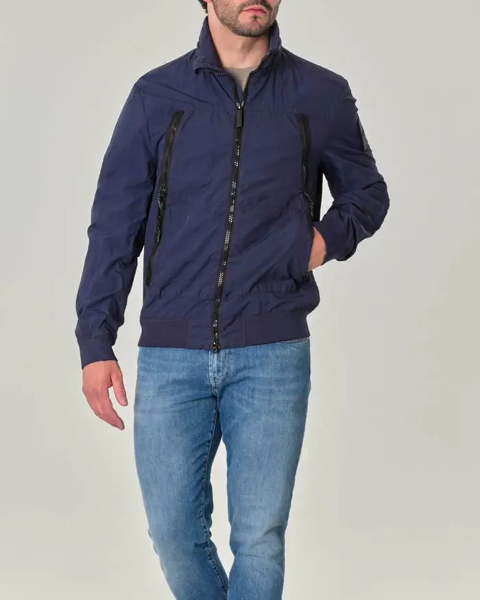 Giubbino blu in nylon crinkle con ampie tasche oblique con doppio cursore e cappuccio estraibile